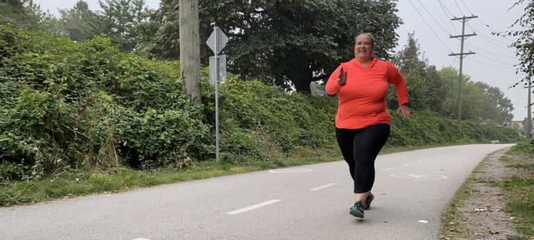 A fat runner running along a paved path