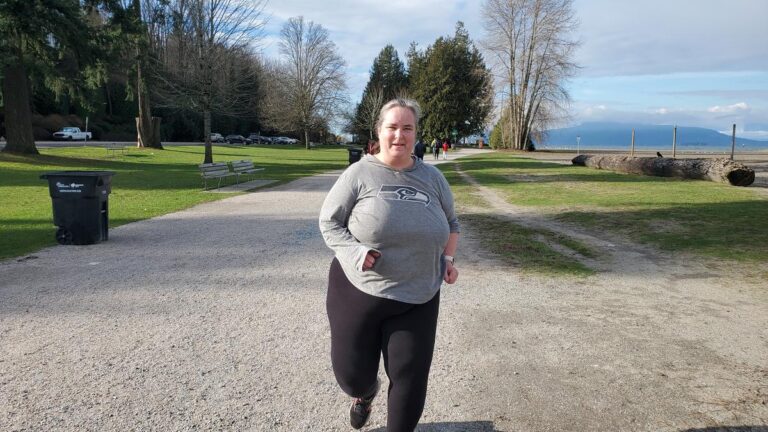 A fat girl running on a seaside trail